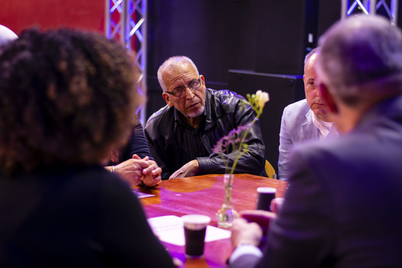 men, group of people, drink, communication, real people, sitting, males, women, indoors, table, adult, togetherness, people, business, food and drink, refreshment, lifestyles, selective focus, mature men