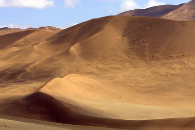 Scenic view of sand dunes against sky