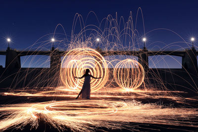 Light trails on fireworks against sky at night