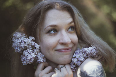 Close up happy woman pressing lilac stems to face portrait picture