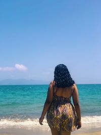 Rear view of woman looking at sea against sky