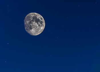 Low angle view of moon against blue sky