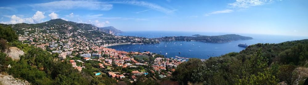 High angle view of city by sea against sky