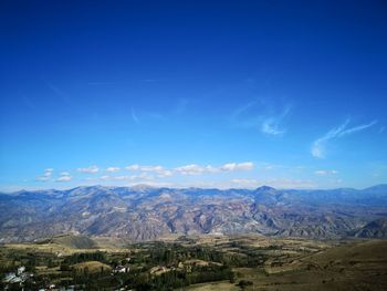 Scenic view of landscape and mountains against blue sky