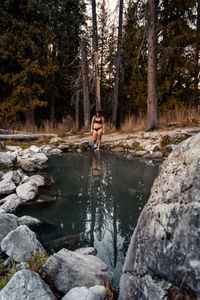 Woman walks into beautiful hot spring with reflection