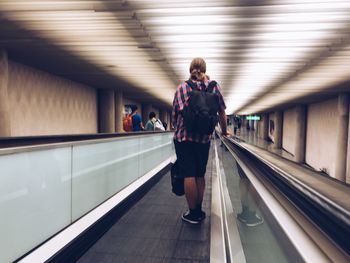 Rear view of man on moving walkway