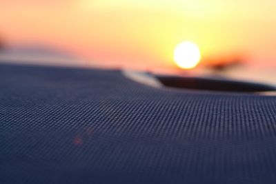 Close-up of illuminated light bulb against sky during sunset