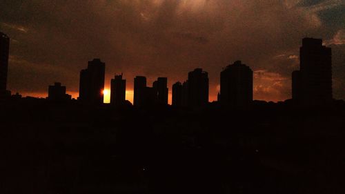 Silhouette cityscape against sky during sunset