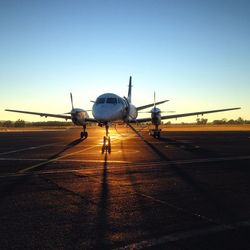 Airplane on runway at sunset
