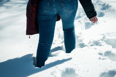 Low section of woman walking on snow