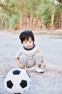 Portrait of boy playing soccer at beach
