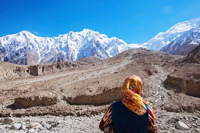 Woman standing on mountain against sky