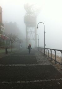 Man walking on footpath in city