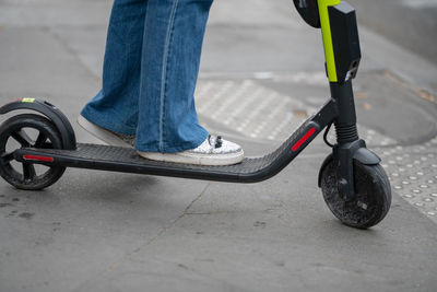 Low section of person on push scooter on street