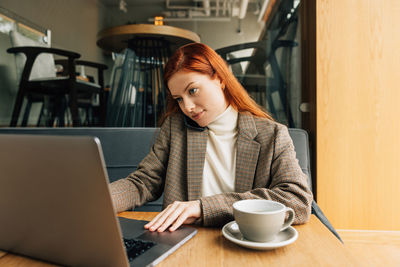 Young woman using laptop at table