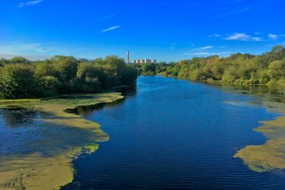 Scenic view of river against blue sky