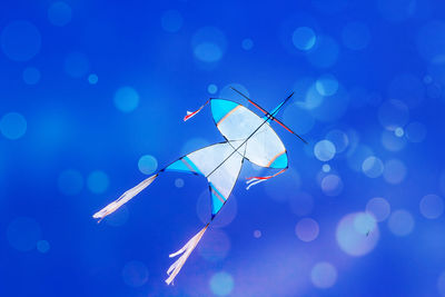 Low angle view of kite flying against clear blue sky