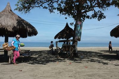 Rear view of people at beach against sky