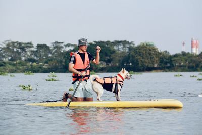 Men on boat in river against sky