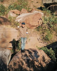 Man standing on rock against trees