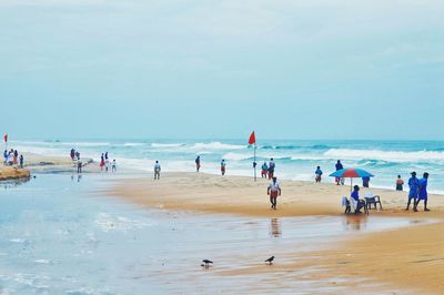 People at beach against sky