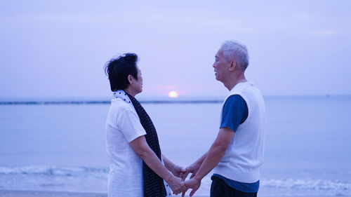 Couple standing in water against sky