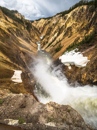 Scenic view of waterfall against sky