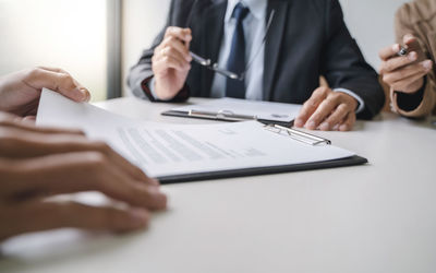 Midsection of man using mobile phone on table