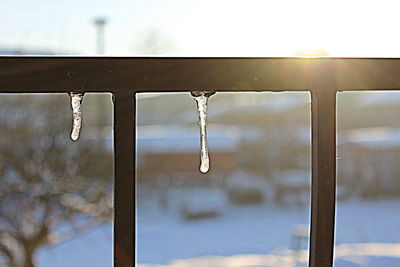 Close-up of water drops on metal against sky