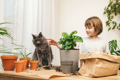 Portrait of cute girl with cat sitting at home