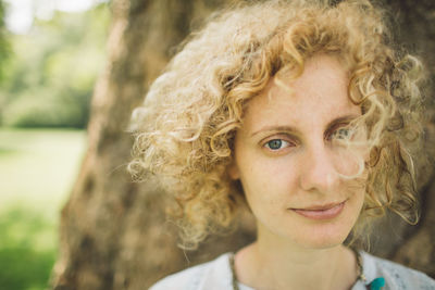 Portrait of smiling young woman with curly blond hair