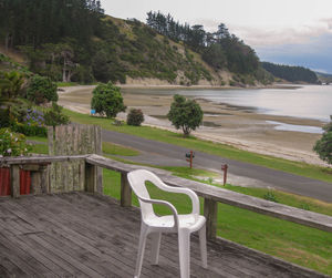 Chairs and table by trees on landscape