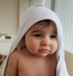 Cute shirtless baby covered with towel at home