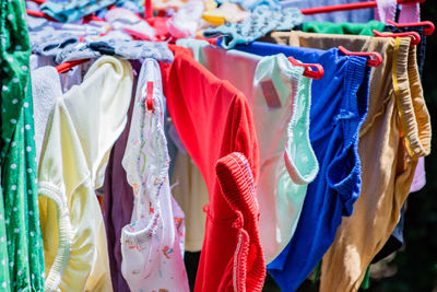 Multi colored clothes hanging on display at store