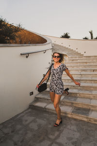 Full length portrait of woman standing against sky