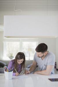 Father helping daughter with homework