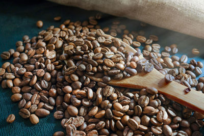 Roasted coffee beans and wooden spoon close-up