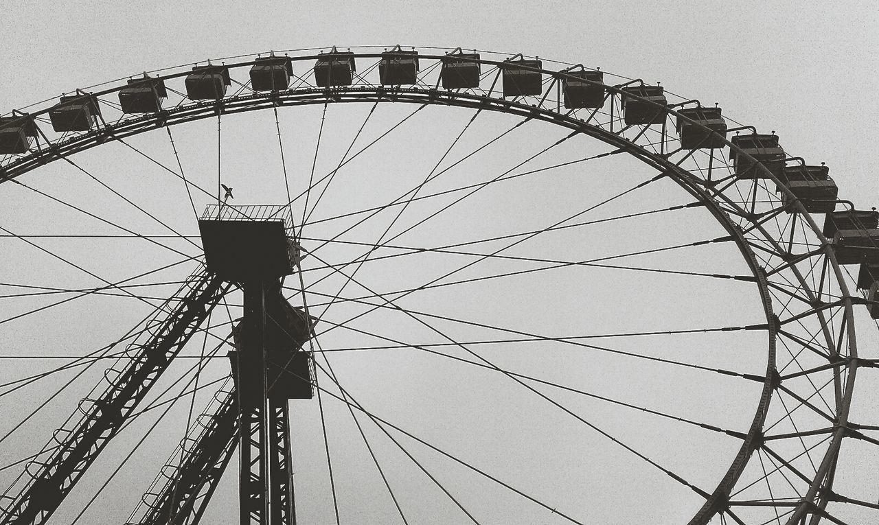 amusement park ride, ferris wheel, amusement park, low angle view, arts culture and entertainment, built structure, architecture, sky, fun, clear sky, leisure activity, outdoors, day, large, fairground, enjoyment, fairground ride, big wheel, circle, travel destinations