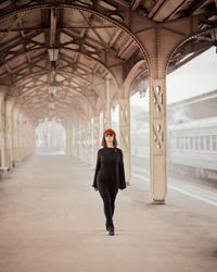 Full length portrait of woman standing in building