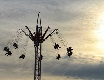Low angle view of chain swing ride against sky