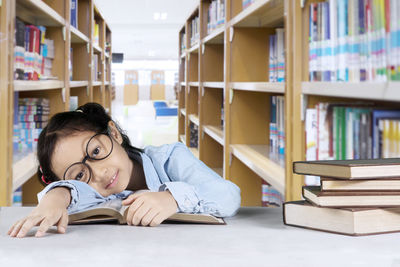 Portrait of smiling girl leaning at table in library