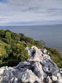 Rocks by sea against sky