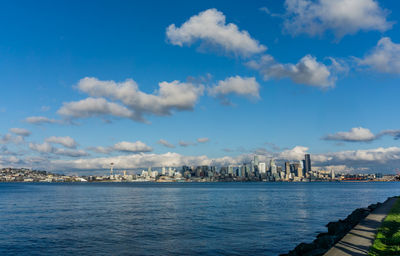 Architecture of the seattle skyline with elliott bay in front and clouds above.