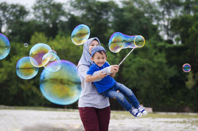 Full length of children playing with bubbles