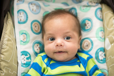 Portrait of cute baby lying on bed