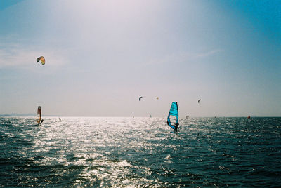 People enjoying in sea against sky