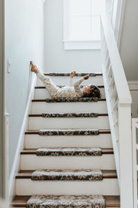 Low angle view of woman lying down on staircase at home