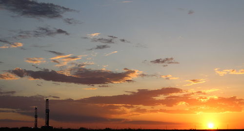 Low angle view of silhouette tower against sky during sunset