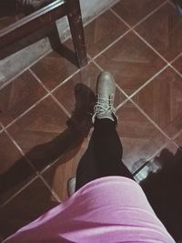 Low section of woman standing on hardwood floor