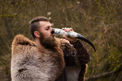 Warrior drinking water from horn in forest